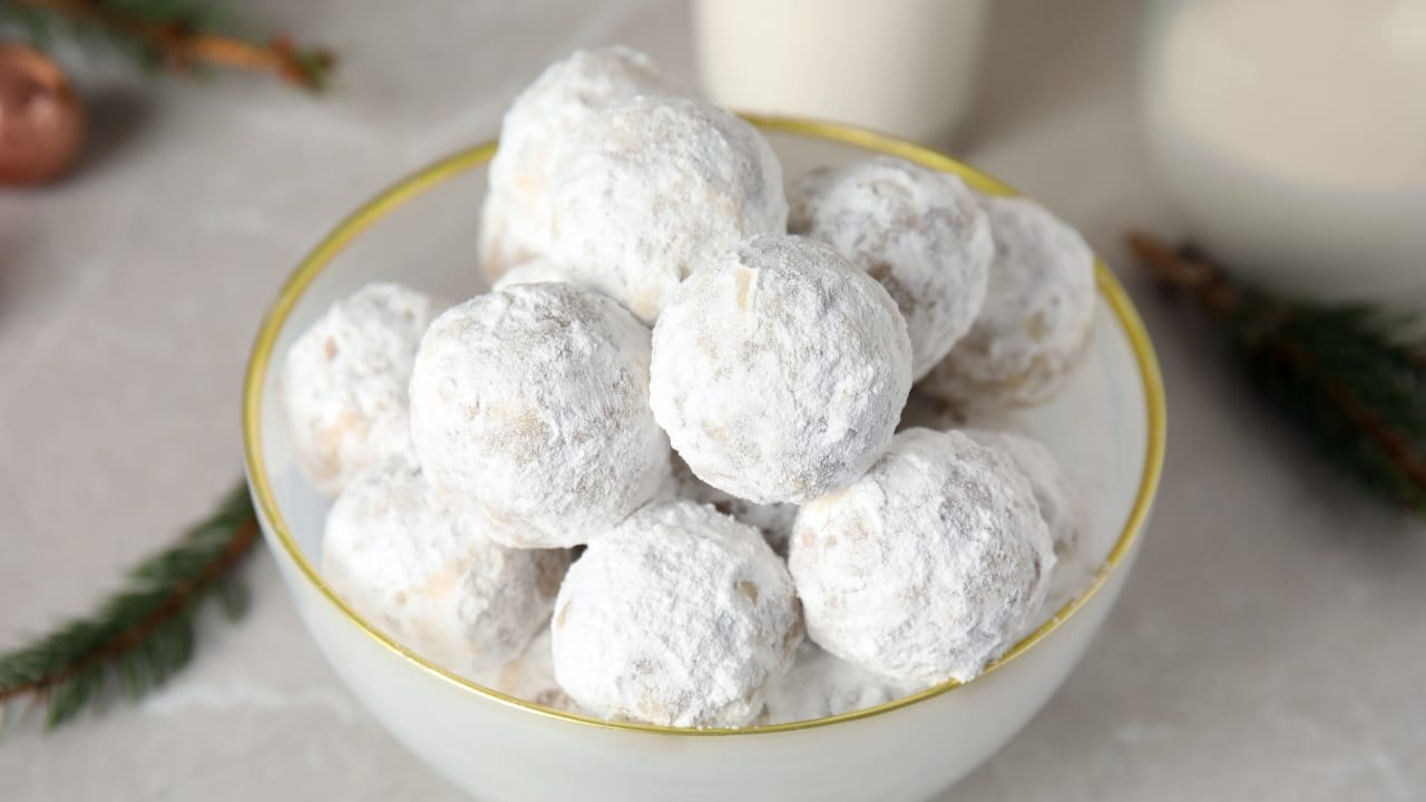 A bowl of freshly baked snowy-white Greek Christmas cookies—Kourabiedes— made using olive oil rather than the traditional butter.