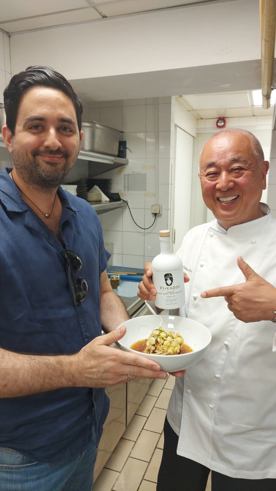 World-renowned chef, Nobu Matsuhisa, stands in Matsuhisa Athens’s kitchen and points to his olive oil of choice, PJ KABOS. The founder and owner of PJ Kabos, James Panagiotopoulos, is proudly standing beside him.