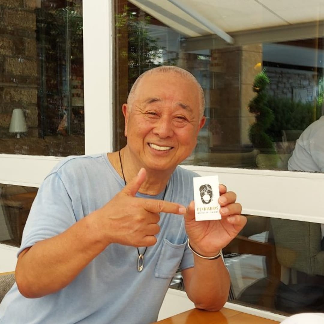 World-renowned chef, Nobu Matsuhisa, pointing to a PJ Kabos business card, the olive oil he uses in his restaurants around the world.