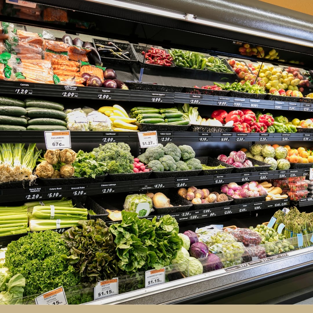 The vibrant shelves of a modern supermarket's produce section showcase a colorful array of fresh vegetables and fruits.