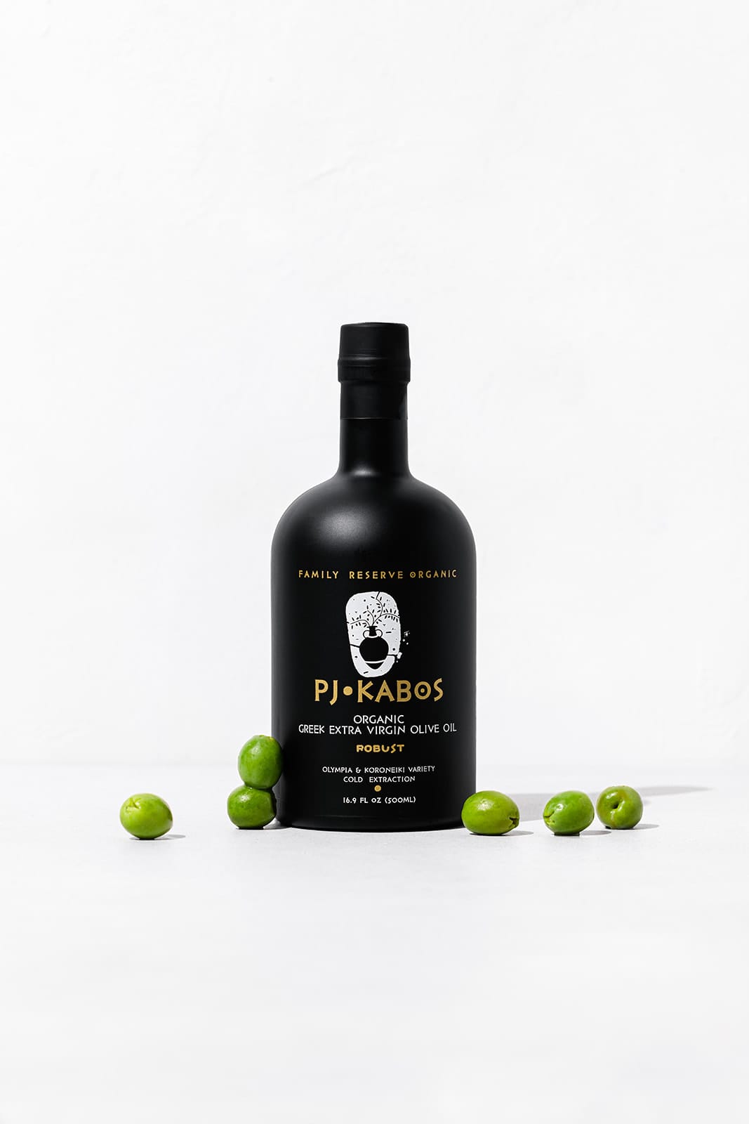 An elegant black bottle of PJ Kabos very high-phenolic robust and organic extra virgin olive oil with olives scattered around it.